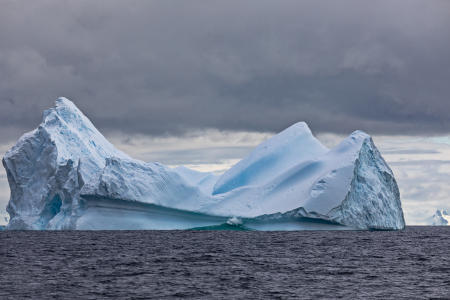 Wave breaking on a large iceberg in the Gerlache Strait, between Trinity Island and the Christiania Islands