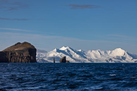 Rounding a point on Deception Island, with Livingston Island in the distance