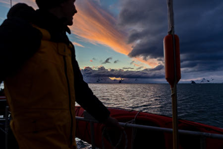 Caesar, one of the ship's crew, watching the sunset off Yankee Harbor, around 10:30 pm